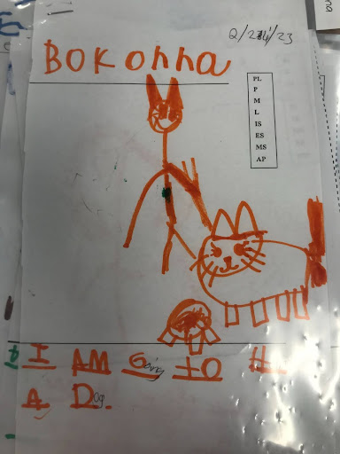 An example of a Play Plan.  Prior to play in one of the centers, scholars write a plan about what center they are going to do, the role they are going to take on, and what they are going to do in the center.  This scholar wrote "I am going to help a dog".  Scholars first learn about the difference between letters and words and then progress to representing words with initial sounds, and grow to adding more sounds to their words.